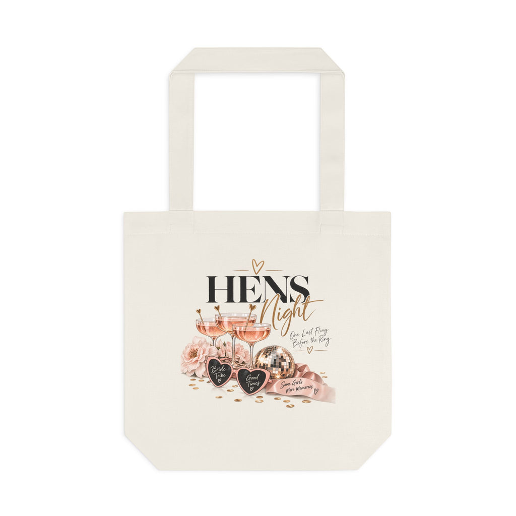 An off-white canvas tote bag with a printed graphic on the front featuring the text 'HENS Night' in black and gold, alongside illustrations of pink roses, glasses of rosé wine, and heart-shaped chocolates, set against a plain white background.