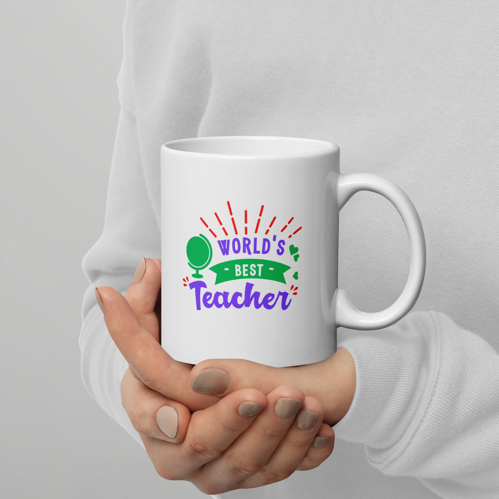 White mug with 'World's Best Teacher' text held by a person against a gray background