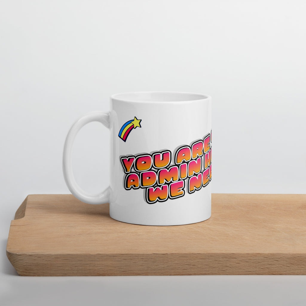 White mug with colorful text and rainbow design on a wooden surface