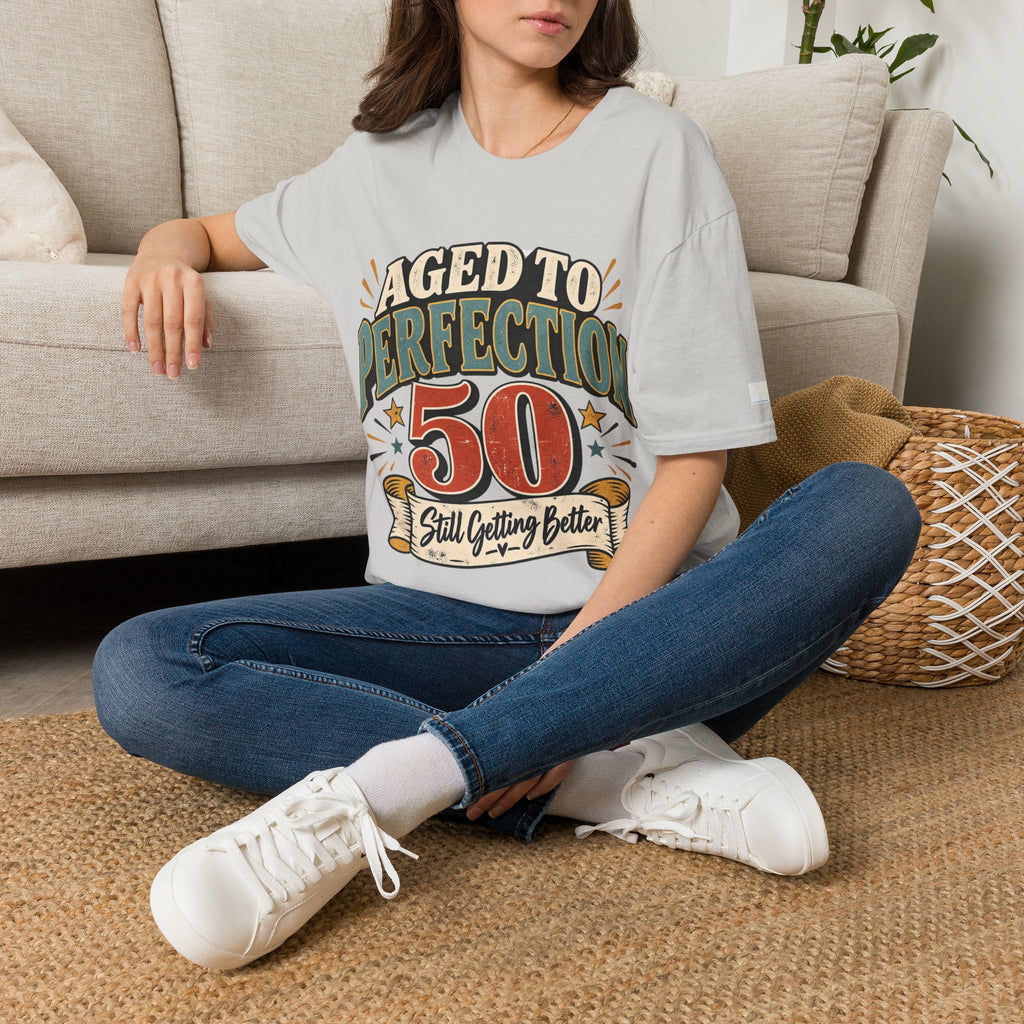 Person wearing a 'aged to perfection' t-shirt sitting on the floor.