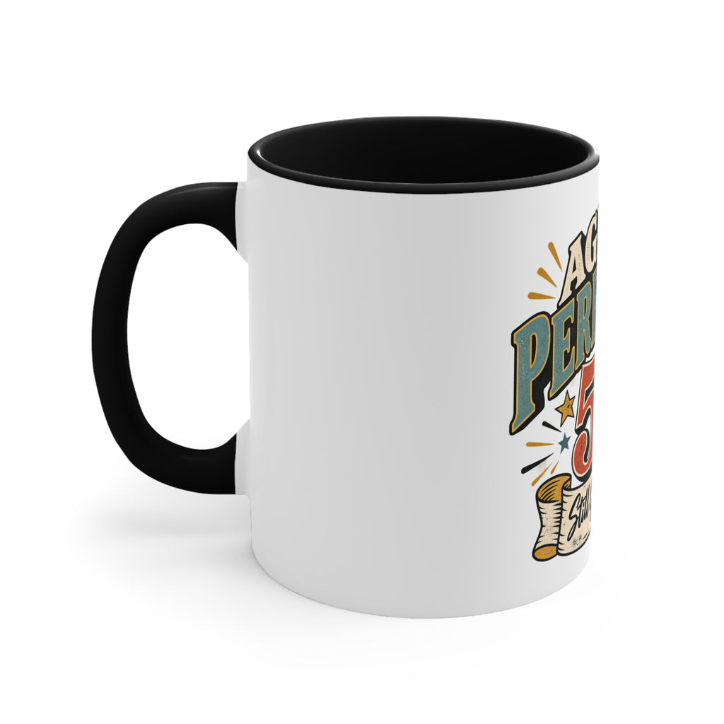 A white ceramic mug with a black handle and black interior, featuring a colorful graphic on the side that reads 'aged to perfection' with stars and a scroll illustration.