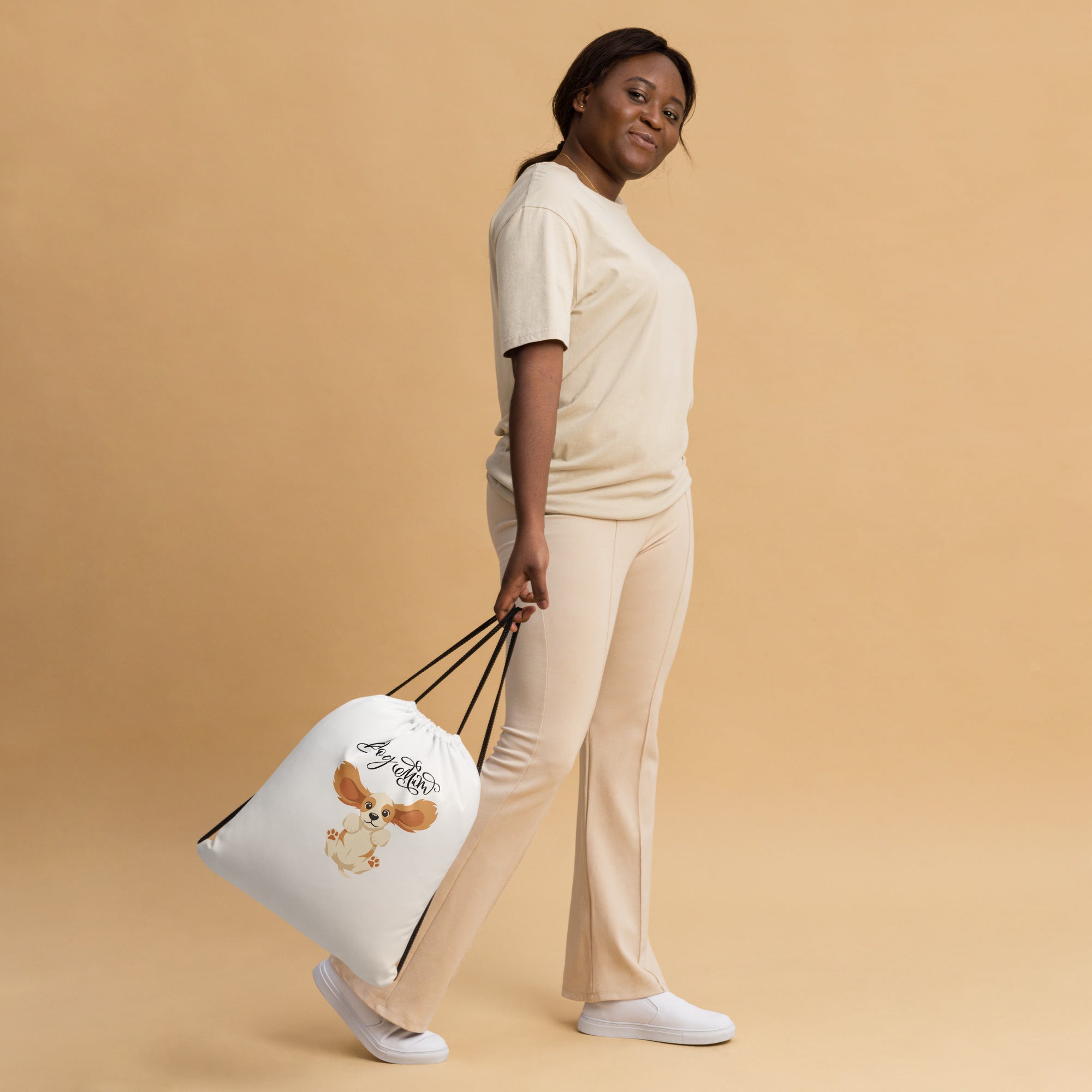 Woman holding a white tote bag against a beige background
