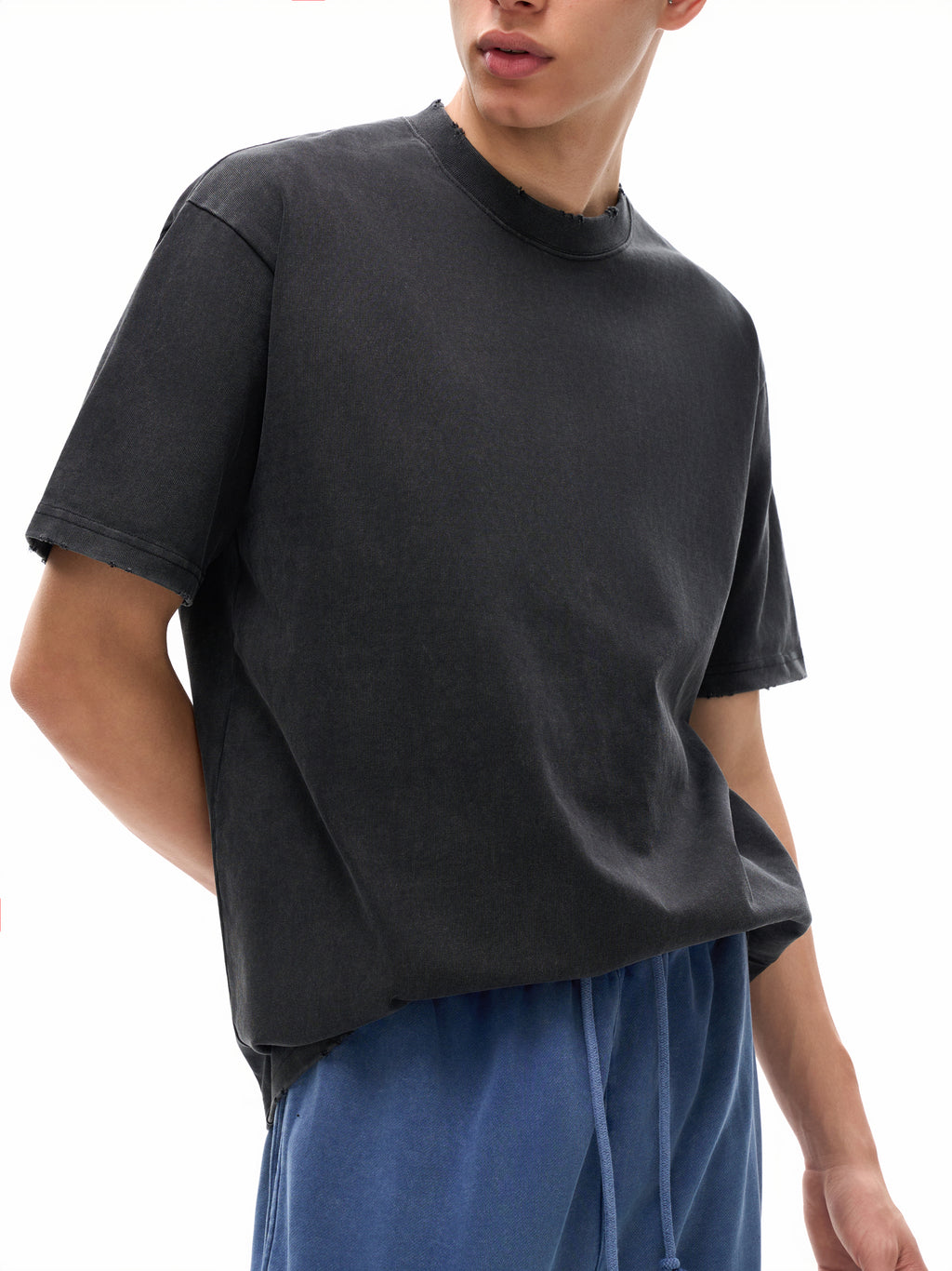 Person wearing a black t-shirt and blue pants on a white background