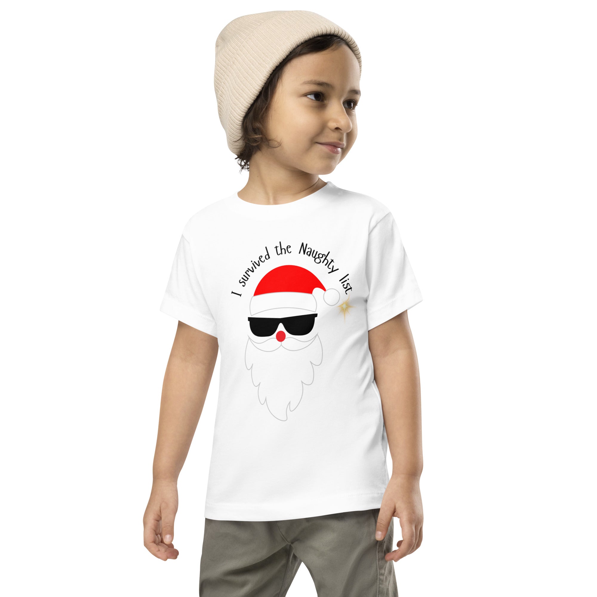 Child wearing a white t-shirt with a Santa Claus graphic and text, standing against a white background.