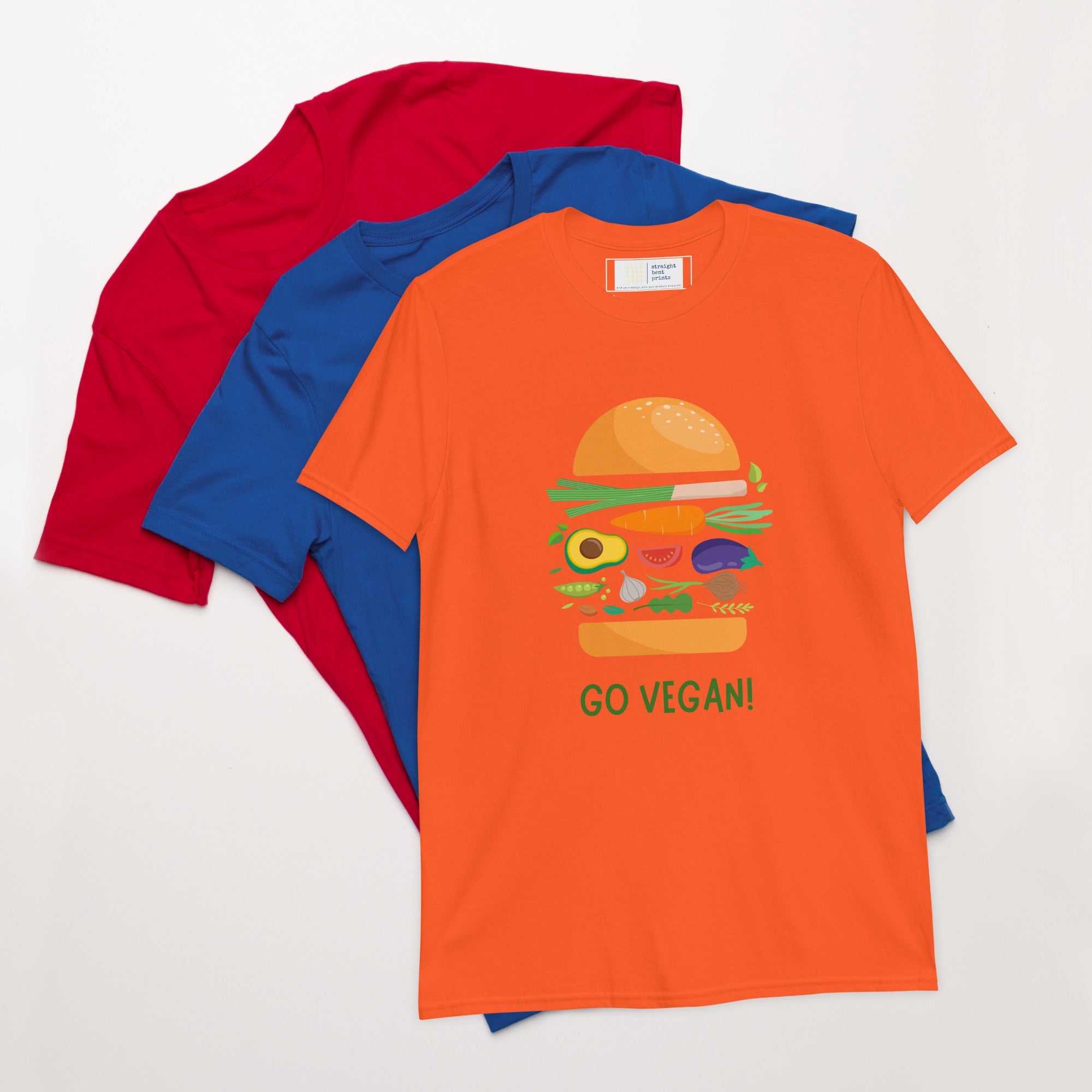 Orange t-shirt with a burger graphic and 'GO VEGAN!' text, surrounded by red and blue shirts on a white background.