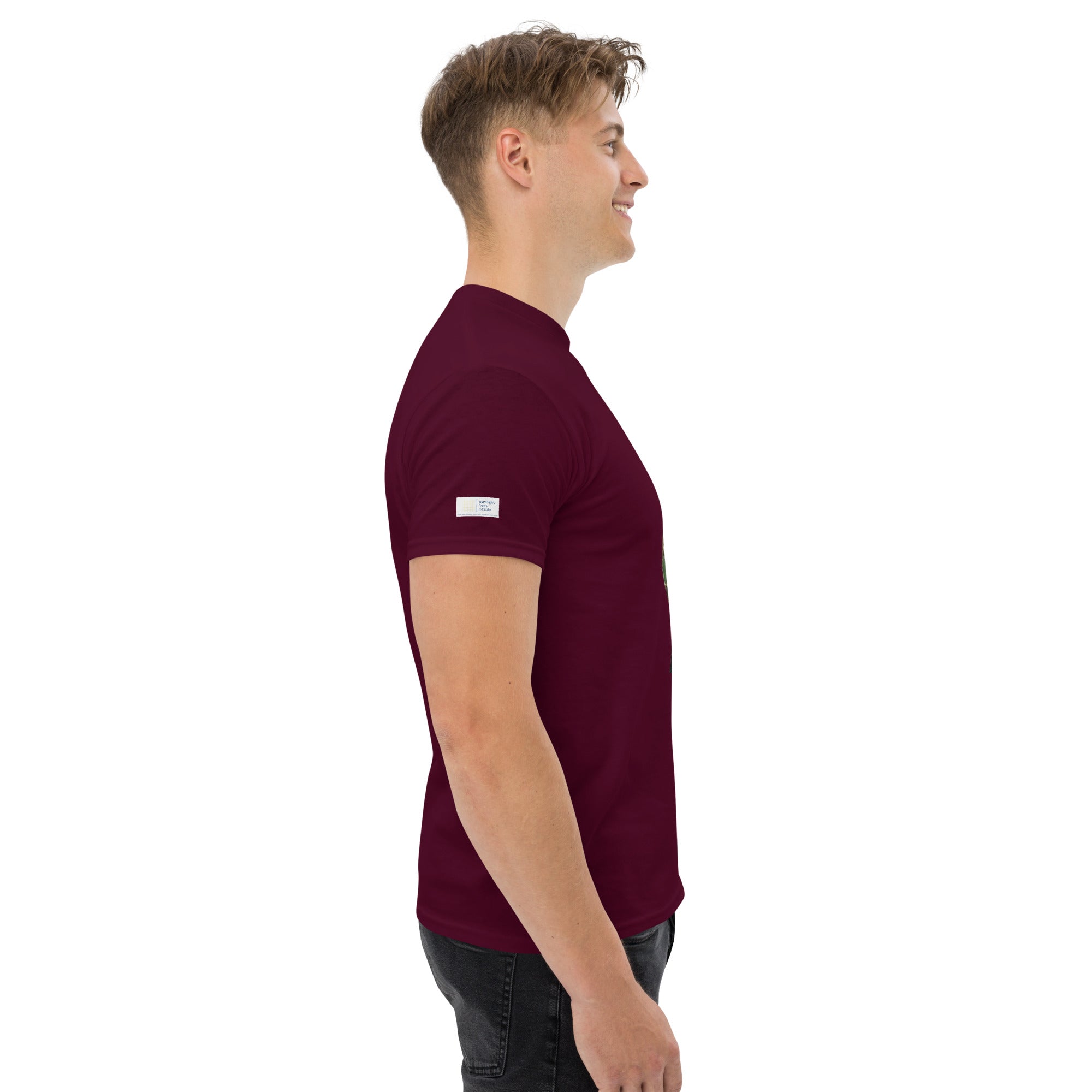 Man wearing a maroon t-shirt with a small white logo on a white background