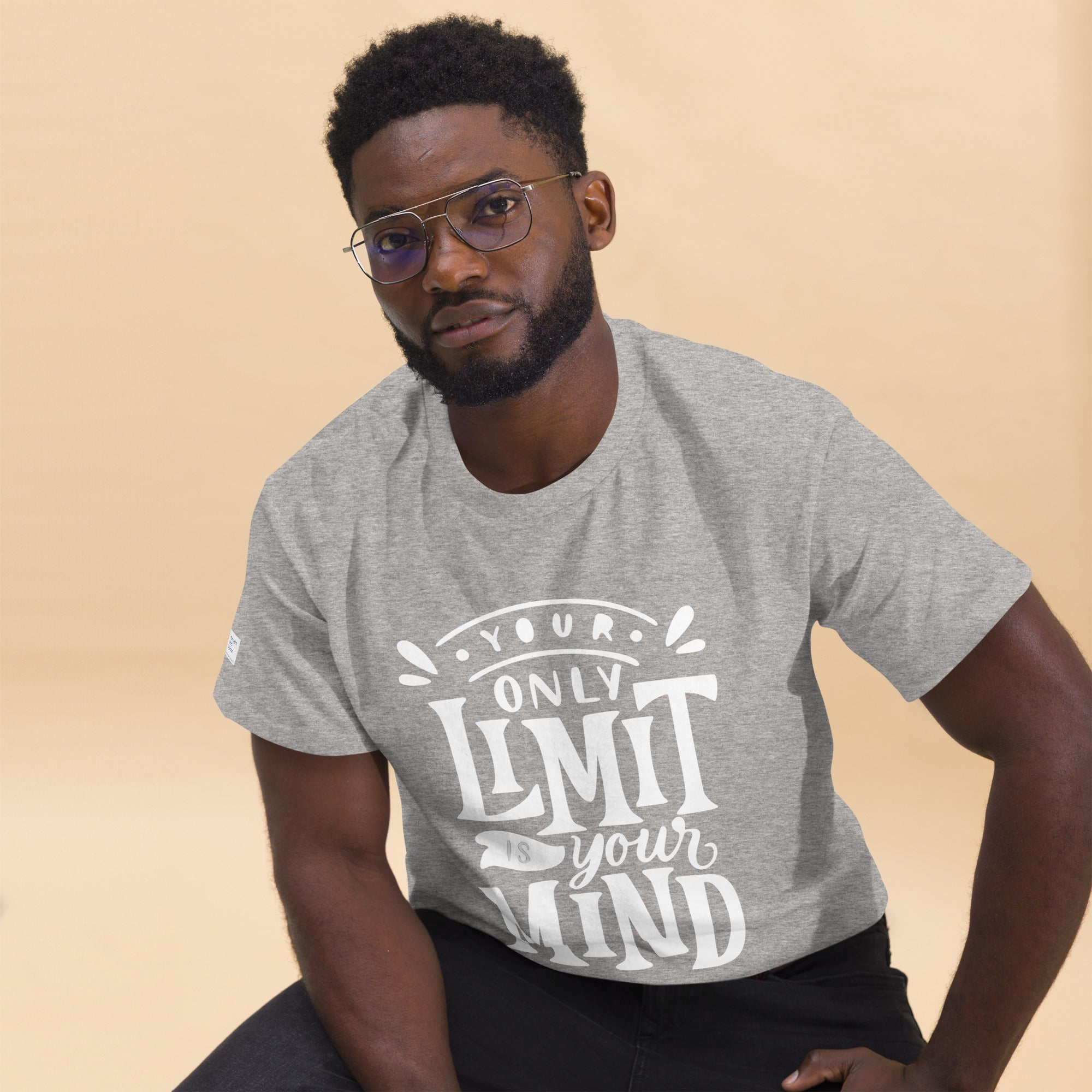 Man wearing a gray t-shirt with motivational text on a beige background