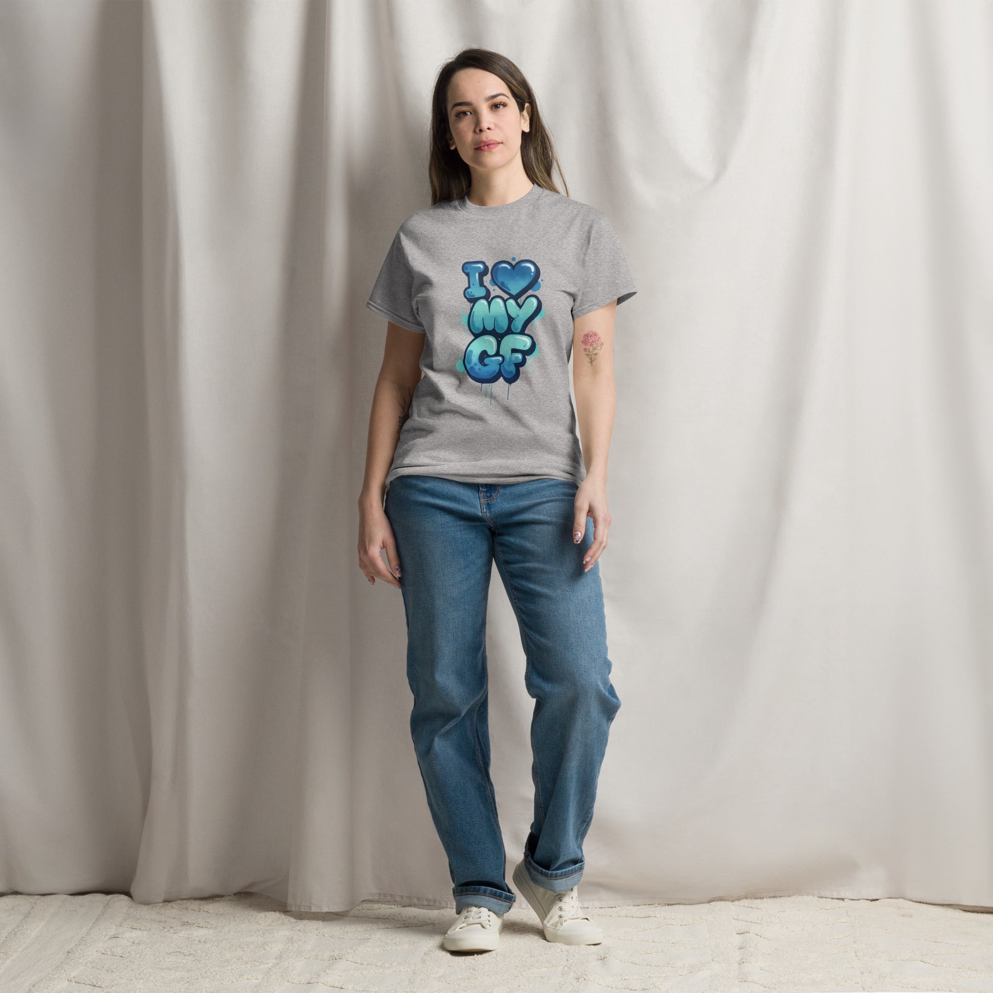 Person wearing a gray t-shirt with 'PEOPLE LIVES MATTER' text and blue jeans against a plain background