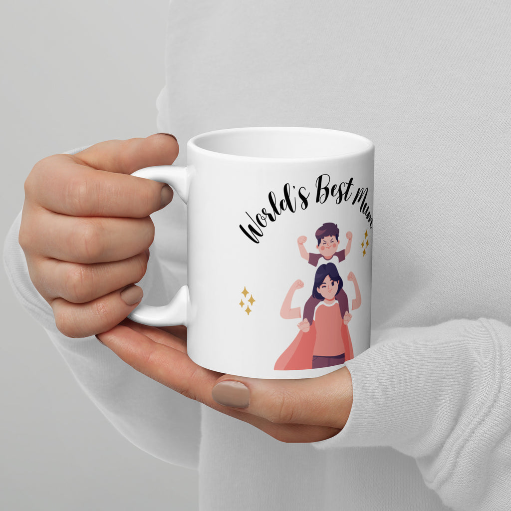 Hand holding a white mug with 'World's Best Mum' text and illustrations on a light gray background