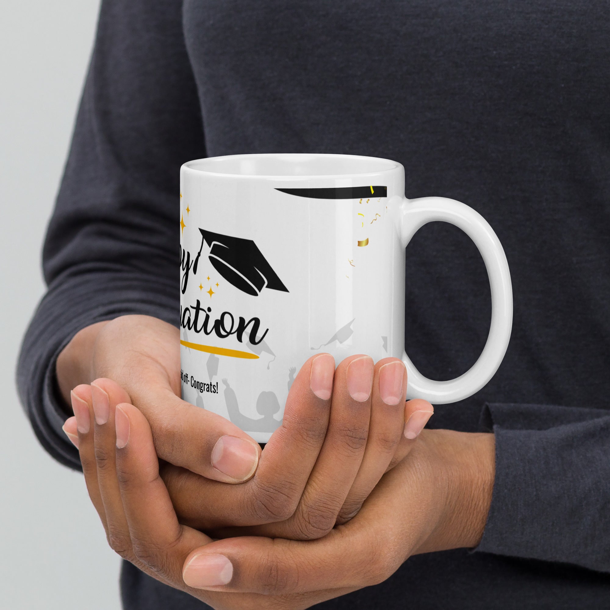 Person holding a white mug with graduation design