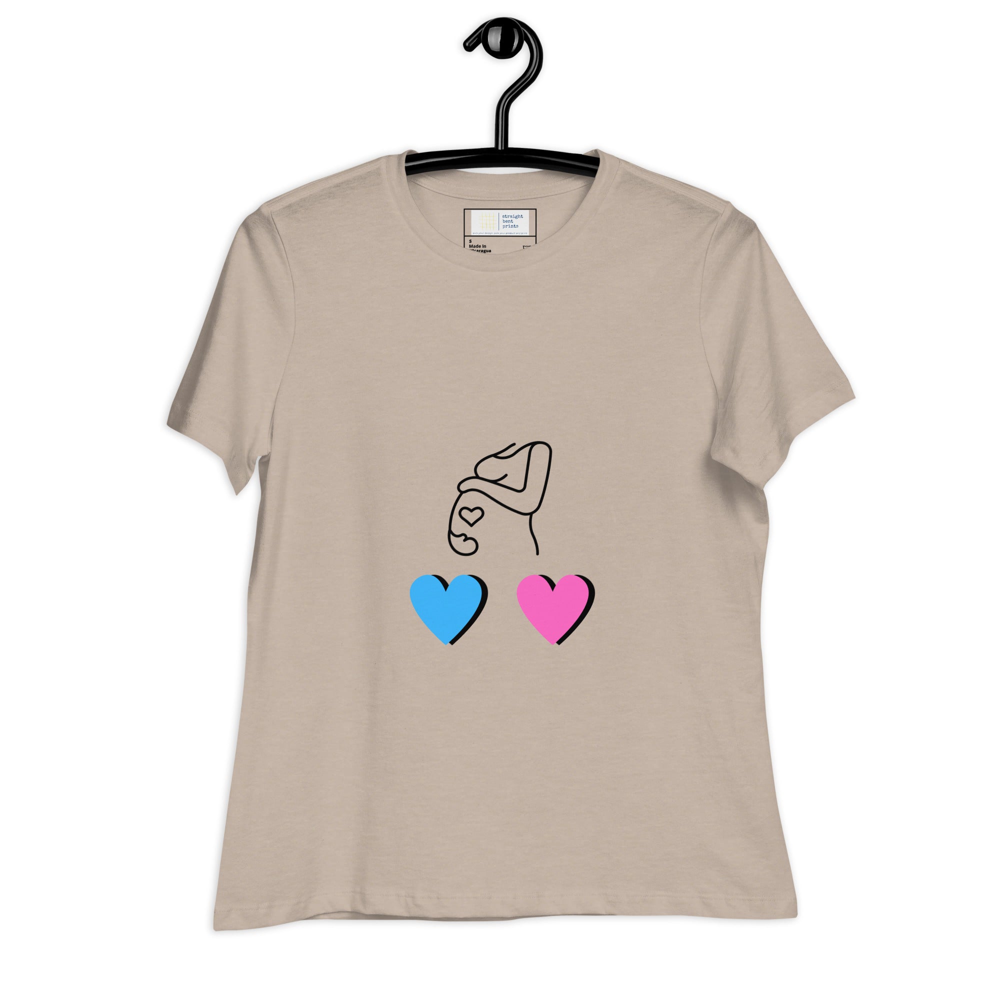 Beige t-shirt with a design of two hands holding hearts in blue and pink, hanging on a black hanger against a white background.